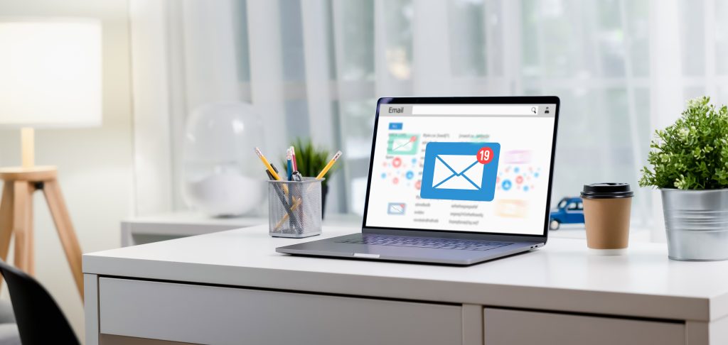 This image shows a laptop on a desk displaying e-mail services